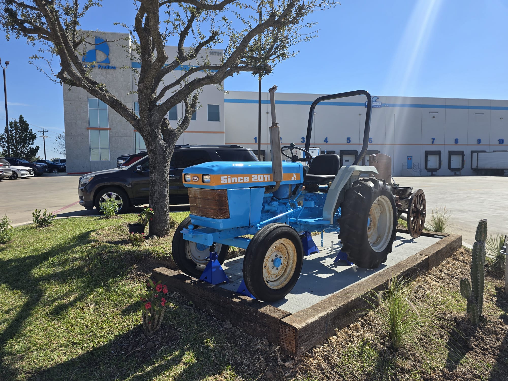 Blue tractor displayed outside the facility during the day